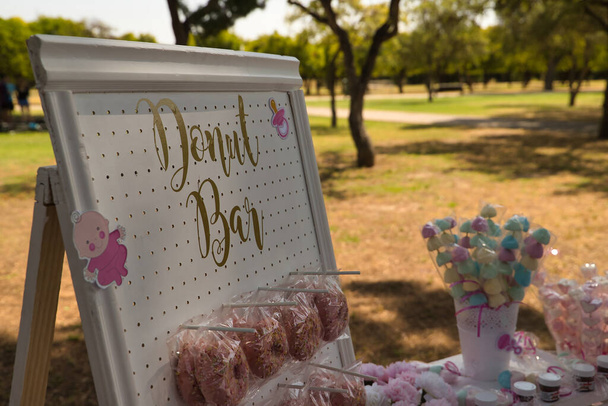 Деталь плаката з рожевими пончиками відображається для святкування вечірки вагітності. На передньому плані
. - Фото, зображення
