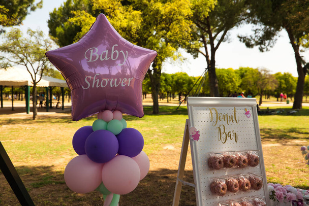 Różowy balon w kształcie gwiazdy i różowe pączki wyświetlacz stojak na uroczystości baby shower. - Zdjęcie, obraz