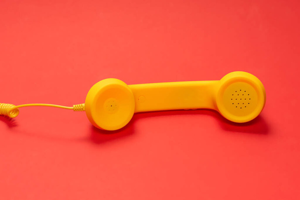 Κίτρινη συσκευή σε κόκκινο φόντο.  - Φωτογραφία, εικόνα