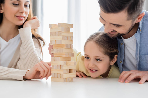 cheerful family playing wood blocks game at home - Foto, immagini