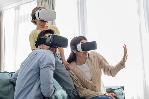 woman gesturing while gaming in vr headsets with frightened family - Foto, afbeelding