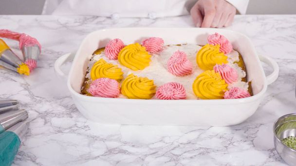 Piping rosettes with Italian buttercream frosting on top of sheet cake. - Photo, Image