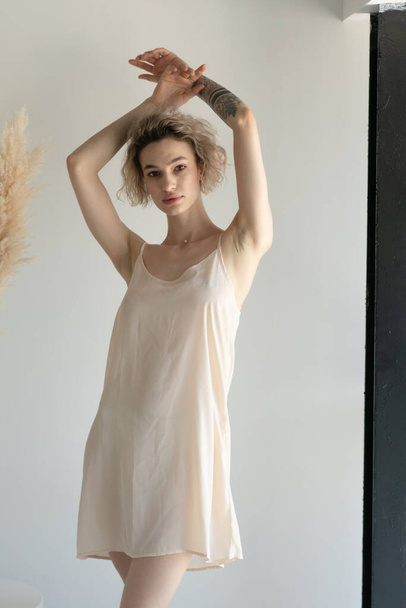 молода красива жінка позує в білій білизні в студії
 - Фото, зображення