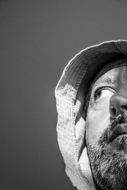 sombere man van middelbare leeftijd met een grijze baard met een badjas op zijn hoofd                              - Foto, afbeelding