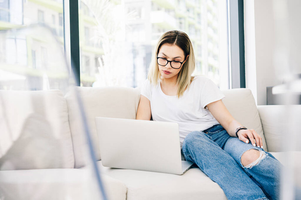Young attractive woman model sitting on a sofa using a laptop - Foto, Bild