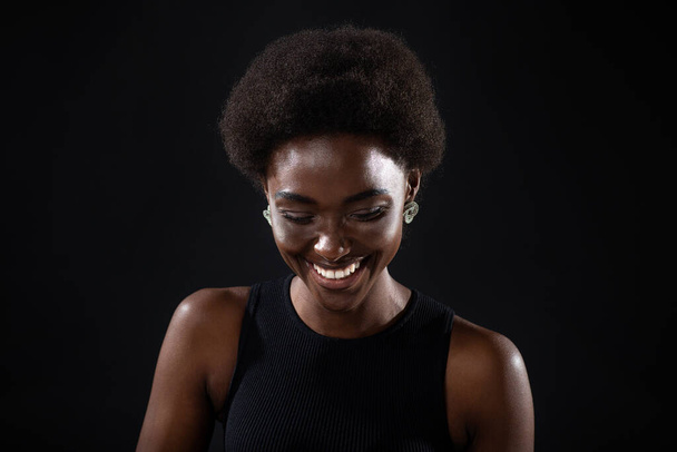 Joven negro positivo africano americano mujer riendo retrato en negro fondo. - Foto, imagen