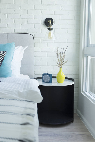 біло-блакитні подушки на зручному ліжку в сучасній спальні
. - Фото, зображення