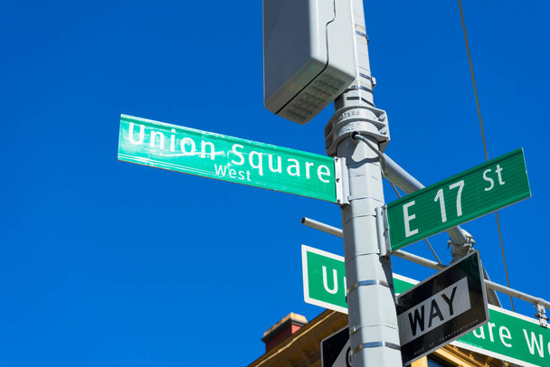 A sign post at the intersection of two streets reading UNION SQUARE WEST and E 17 St in New York. - Photo, Image