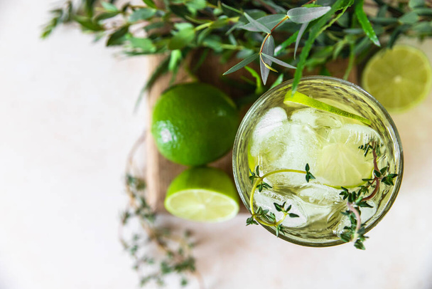 Refreshment infused water with lime and thyme. Healthy drink and detox concept. Summer beverage. Selective focus. Top view. - Фото, зображення
