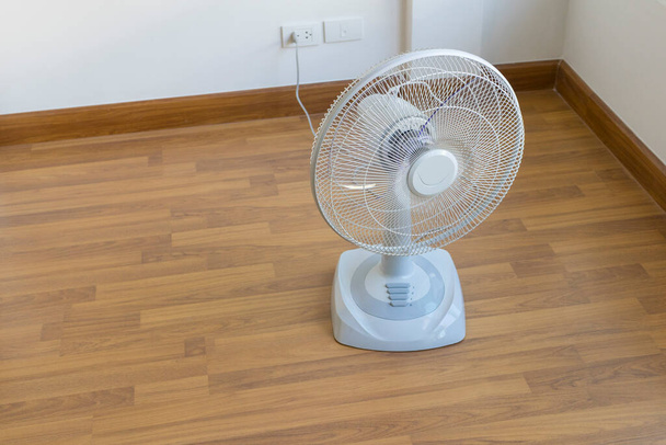 Ventilatore elettrico da tavolo sul pavimento in legno - Foto, immagini