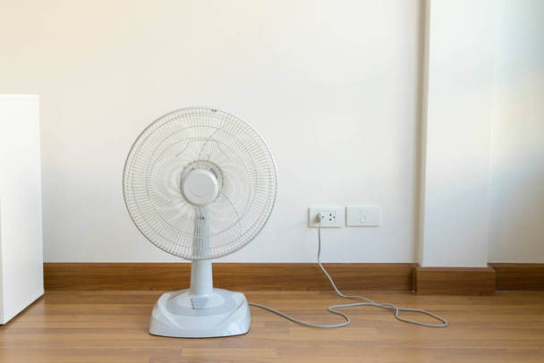 Asztali elektromos ventilátor a fa padlón - Fotó, kép