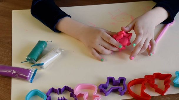 Тоддлер руки играют красочные тесто с пластиковыми формами - Фото, изображение