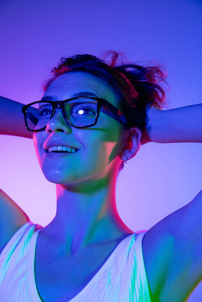 Young womans portrait on gradient colors studio background in neon. Concept of human emotions. - Foto, afbeelding