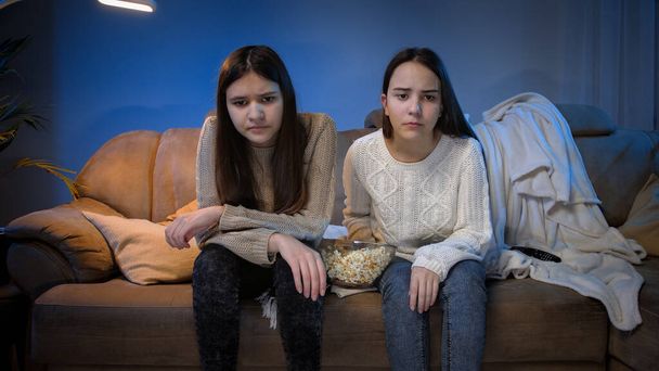Kaksi teini tytöt saada järkyttynyt ja harmitti jälkeen joukkue menettää urheilu ottelu televisiossa yöllä - Valokuva, kuva