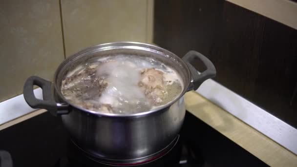 Boiling meat broth in a saucepan on the stove. Home cooking - Footage, Video