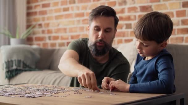 Handheld video of boy solving jigsaw puzzle with father. Shot with RED helium camera in 8K. - Footage, Video