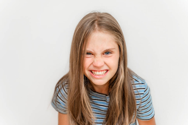 Porträt eines kleinen Mädchens grinst und macht Gesichter - Foto, Bild