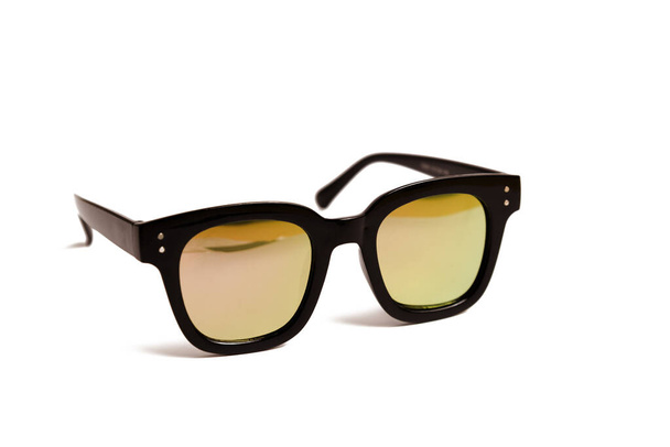 Schwarze Sonnenbrille und gelbe Gläser auf weißem Hintergrund - Foto, Bild