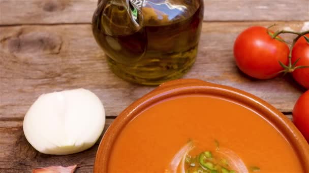 Gazpacho andaluz, hergestellt mit Tomaten, Zwiebeln, Knoblauch, grünem Paprika und Olivenöl, ein typisches Getränk aus dem Süden Spaniens, aus Andalusien auf einem Holzsockel - Filmmaterial, Video