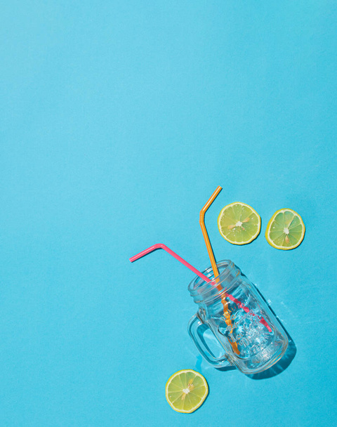 kesälasi, jossa on putki ja sitruunaviipale sinisellä taustalla. abstrakti idea. vähäinen tausta-ajatus - Valokuva, kuva