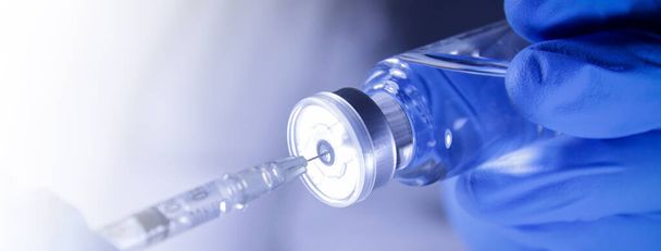 Egy orvos vagy kutató egy fecskendőt és egy vakcinát tartalmazó injekciós üveget tart. Injekcióra a betegnek, hogy immunitást építsen ki Megelőzze a vírusfertőzést. Az orvosi ellátás fogalma A koronavírus terjedésének megakadályozása - Fotó, kép