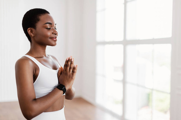 Senhora negra meditando mantendo as mãos juntas em pose de oração - Foto, Imagem