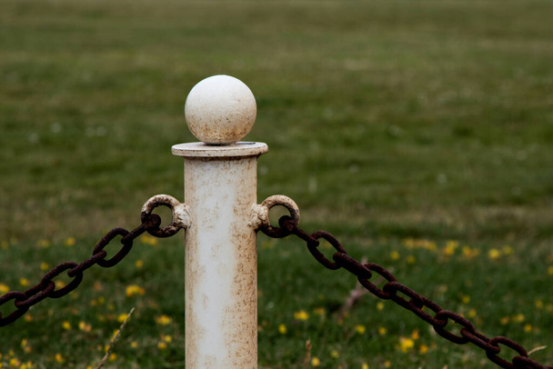 Cadeia de metal velho cerca stanchion com cerca de corrente em um parque de campo - Foto, Imagem