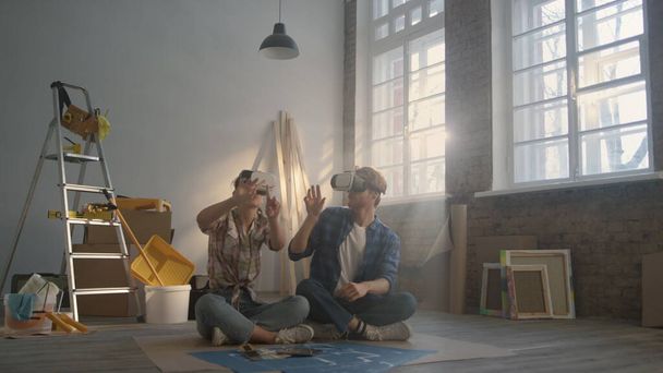 Focused couple working in vr glasses indoors. Family making layout in headsets. - Photo, Image