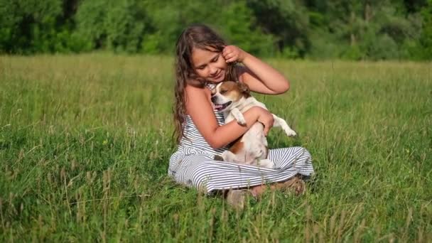 lindo poco caucásico chica mascota su perro al aire libre - Imágenes, Vídeo
