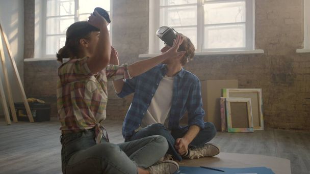 VR gözlüklü bir aile tamirat sırasında yerde oturuyor. Yeniden tasarlama kavramı. - Fotoğraf, Görsel