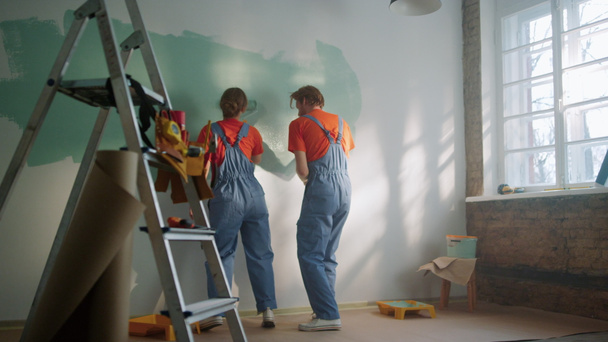Felice coppia pittura muro al chiuso. Famiglia che balla durante la decorazione in casa. - Foto, immagini