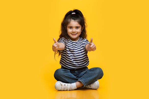 Portret Śliczny Mały Uśmiechnięty Arab Dziewczyna Wyświetlanie Kciuki w górę przed kamerą - Zdjęcie, obraz