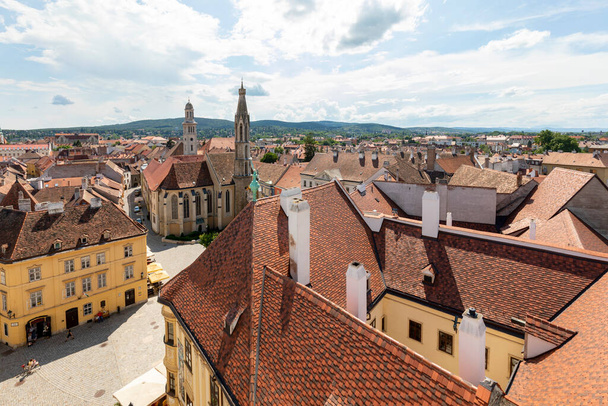 повітряний вид на місто з дахами та фоном блакитного неба
 - Фото, зображення