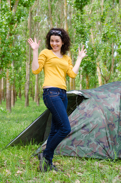 Happy young woman posing in front of a tent - Photo, Image