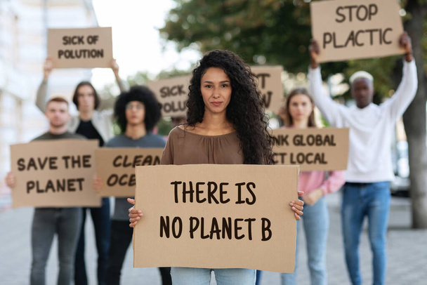 Female leader leading international group of protestors against pollution - Foto, afbeelding