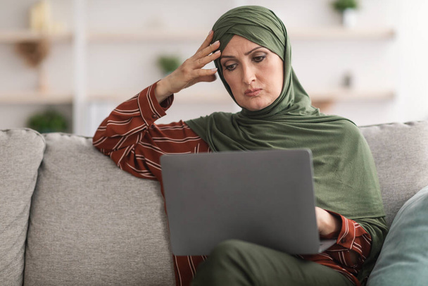 Concerned Middle-Aged Muslim Lady Using Laptop Working Online At Home - Photo, Image