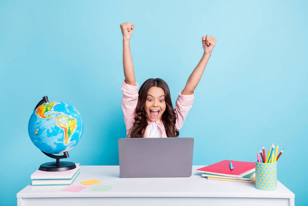 Photo of young happy excited positive good mood happy girl raise fists in victory doing homework isolated on blue color background - Fotografie, Obrázek