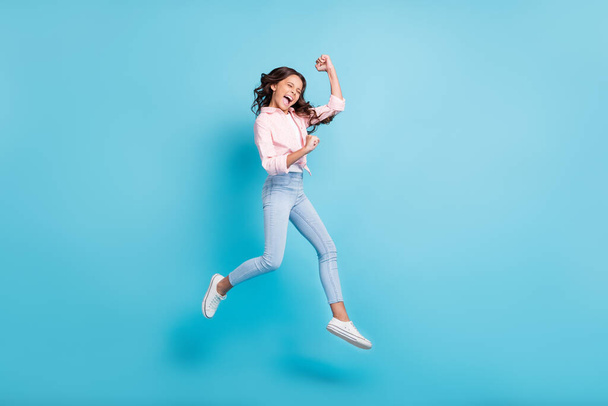 Full size photo of young happy crazy smiling ecstatic girl jumping in victory say yes isolated on blue color background - Foto, immagini