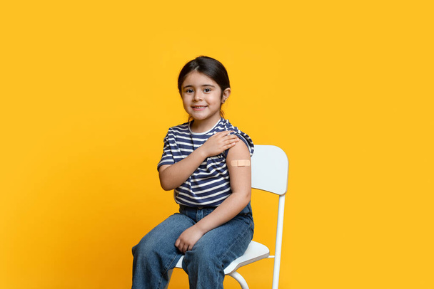 Portret słodkiej małej arabskiej dziewczynki pokazano ramię po szczepieniu koronawirusem - Zdjęcie, obraz