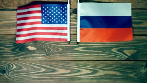 Vlaggen van de VS en Rusland wijzen in verschillende richtingen en zwaaien in de wind. Top VS en Rusland. Vergadering van de presidenten van de Verenigde Staten en de Russische Federatie. Kopieerruimte - Video