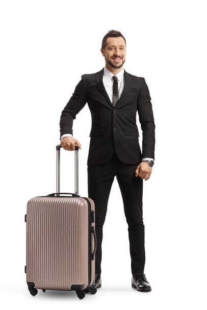 Full length portrait of a businessman holding a suitcase with a handle and smiling isolated on white background - Foto, afbeelding
