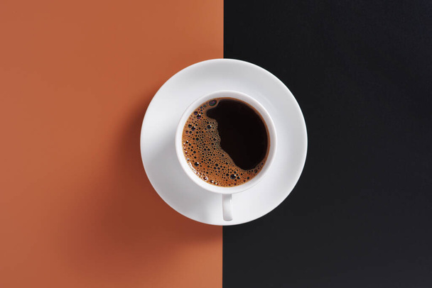 Taza de café sobre fondo marrón-negro, vista superior  - Foto, Imagen