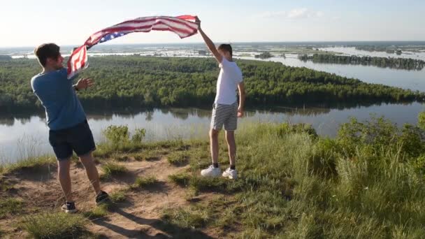 Carino giovane ragazzo e suo padre tenendo in alto la bandiera americana - Filmati, video