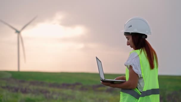 Femme Ecologie Spécialiste Vérification avec ordinateur portable Fonctionnement correct Moulins à vent Coucher de soleil - Séquence, vidéo