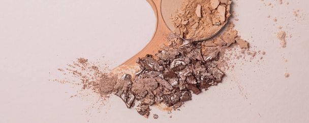 Crashed beige face finishing and liquid powder and cracked eyeshadow. Macro texture of make-up on beige background - Photo, Image