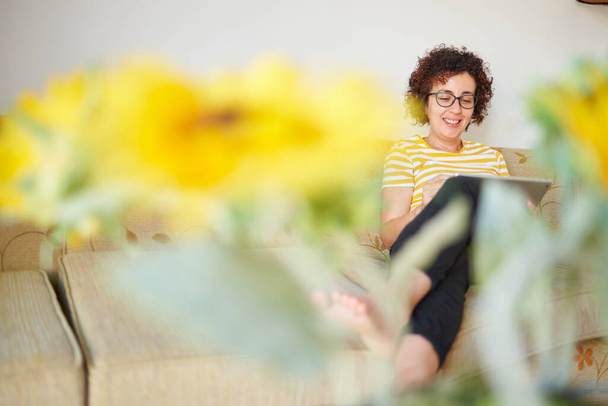 Nainen istuu sohvalla digitaalinen tabletti - Valokuva, kuva
