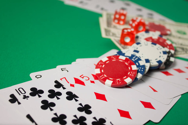 Classic playing cards, chips, red dice and dollars on green background. Gambling and casino concept. - Фото, зображення
