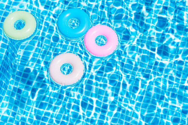 Vista superior de varios colores flota en la piscina. Concepto de verano. Ilustración 3d - Foto, imagen