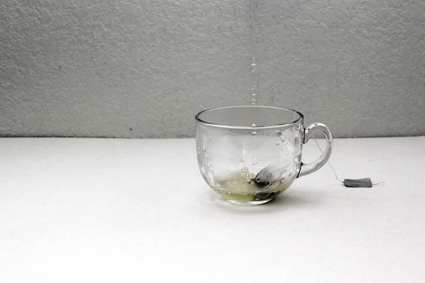 Herramientas para preparar y servir té de hierbas: taza de vidrio, infusor, sobres, hierba deshidratada seca, cuchara para relajarse y curar enfermedades - Foto, imagen