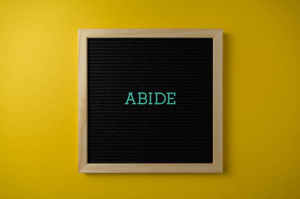 Abide Sign on Yellow Background - Valokuva, kuva